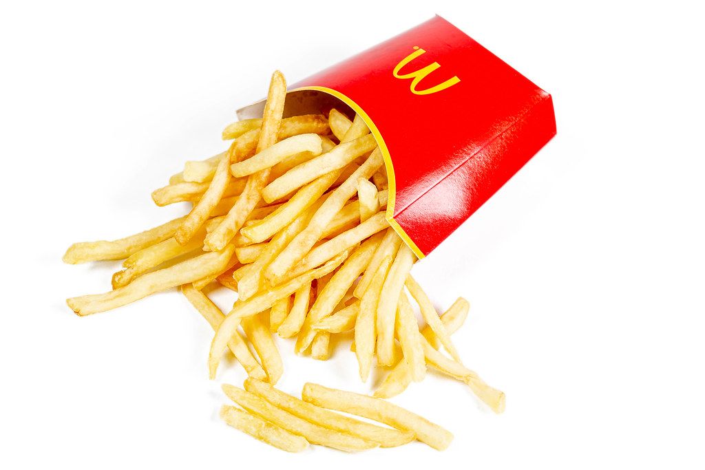 French fries scattered on a white background with a red box