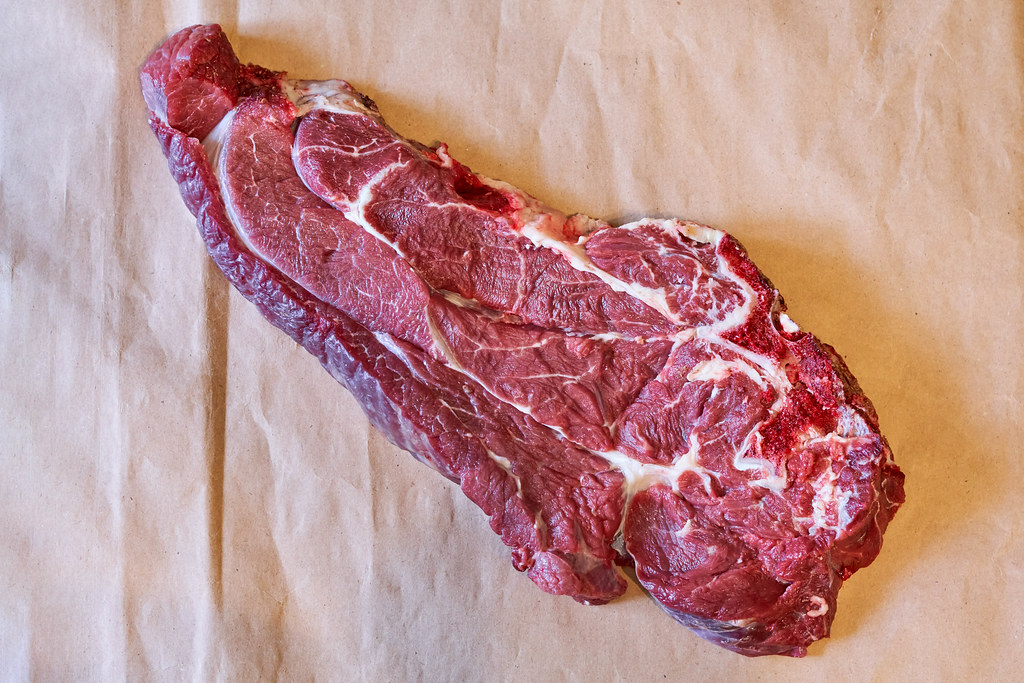 Fresh raw beef steak on craft paper