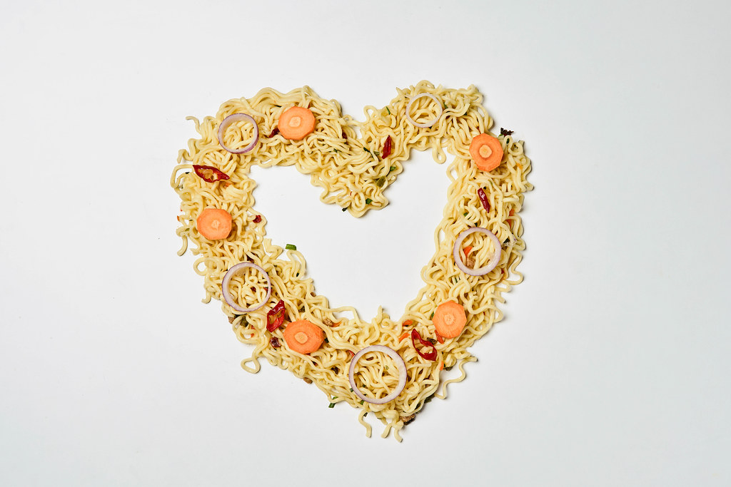Freshly cooked spicy instant noodles in shape of heart