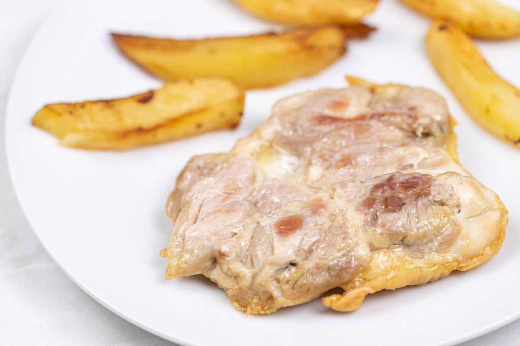 Fried Chicken meat served with fried potatoes on the plate