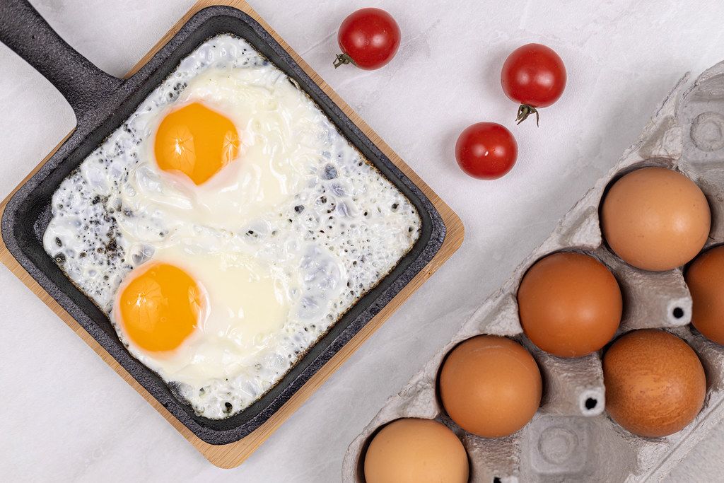 Fried Eggs in the frying pan with Cherry tomatoes