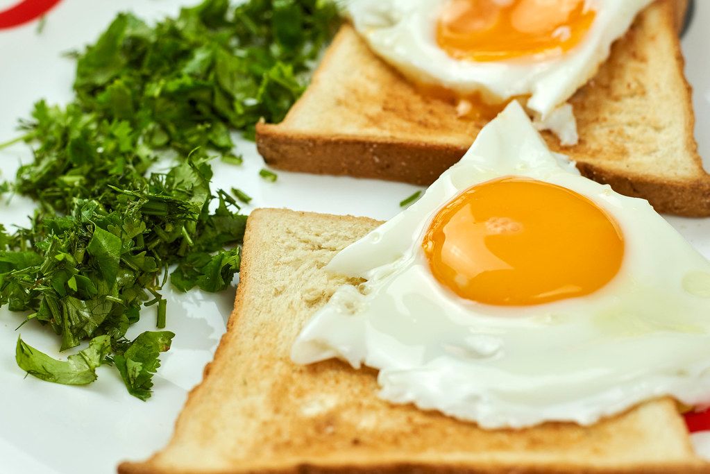 Fried eggs on the toasts. Delicious breakfast full with vitamins and nutrition