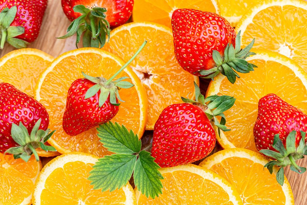Fruit background with fresh orange slices and strawberries