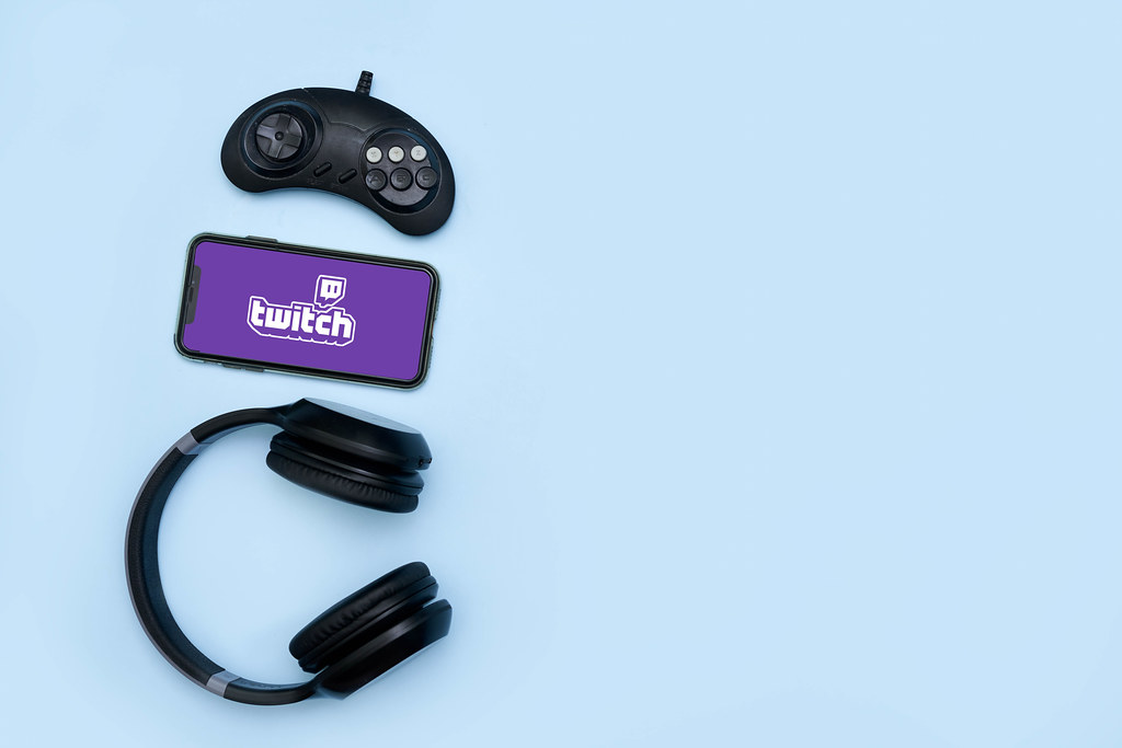 Game controller, wireless headset and mobile phone with Twitch logo on the display