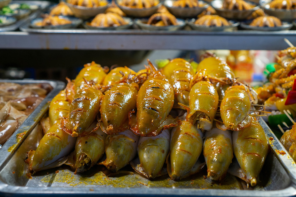 Gegrillter Kalmar und andere Meeresfrüchte bei einer Straßenküche auf einem Nachtmarkt in Vietnam