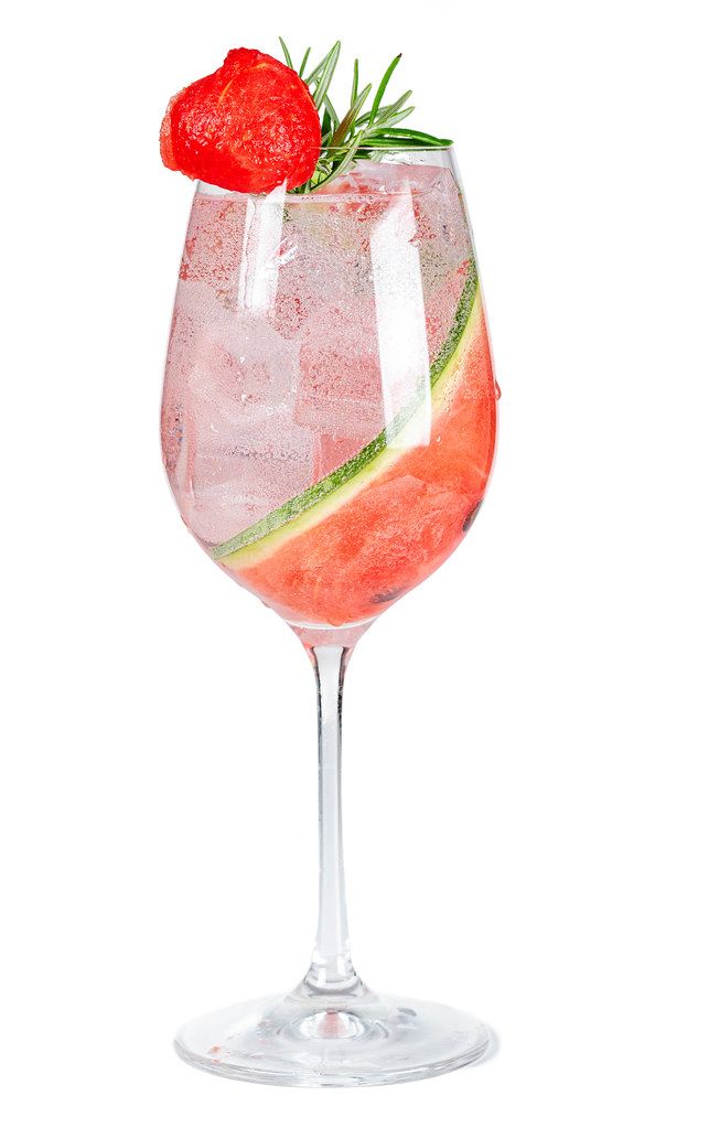 Glass of refreshing watermelon drink with ice and rosemary on a white background