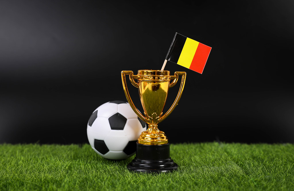 Golden trophy and football ball with flag of Belgium