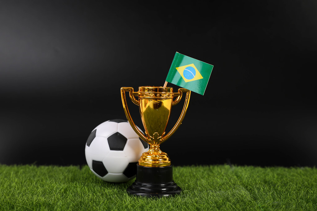 Golden trophy and football ball with flag of Brasil