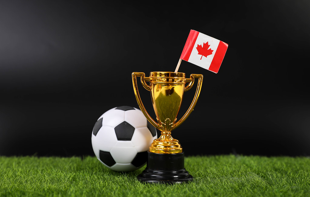 Golden trophy and football ball with flag of Canada
