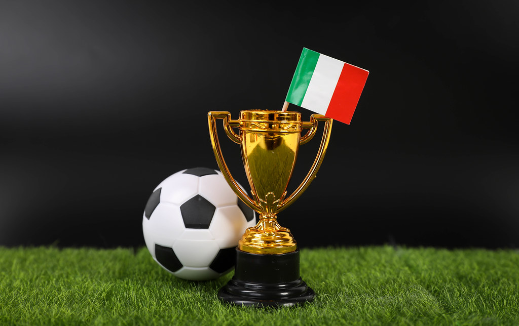 Golden trophy and football ball with flag of Italy