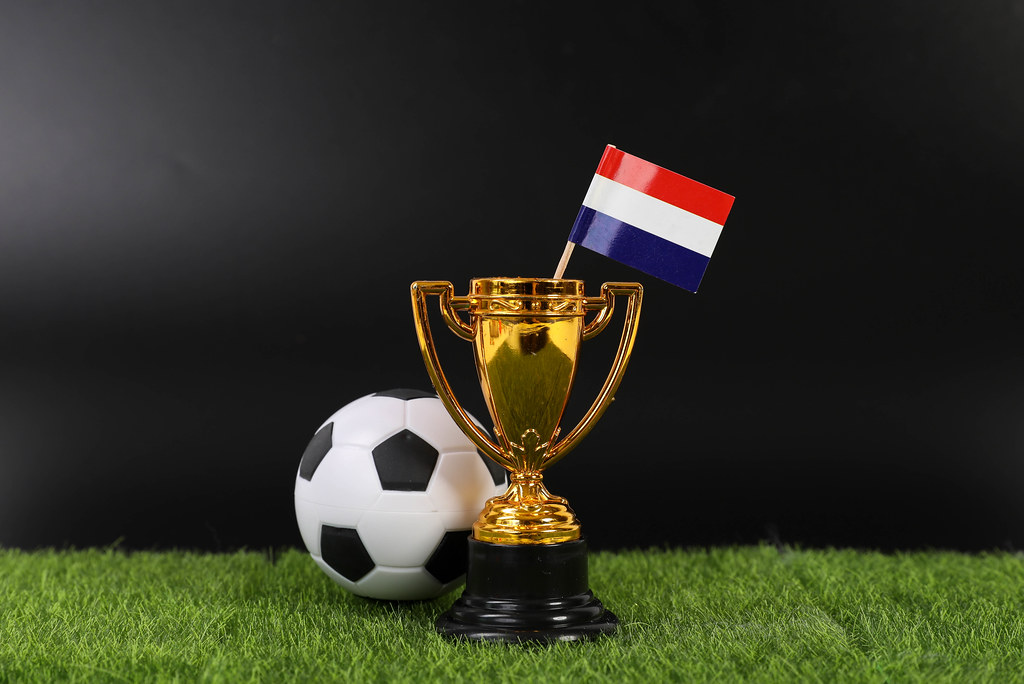 Golden trophy and football ball with flag of Netherlands