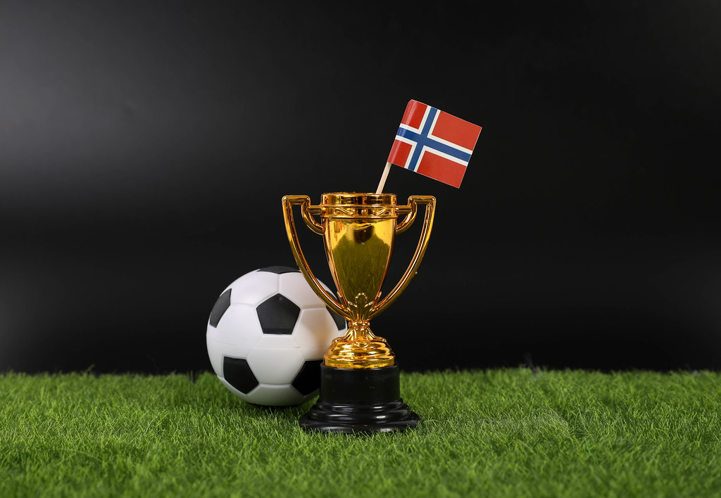 Golden trophy and football ball with flag of Norway