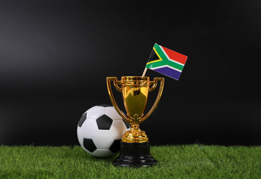 Golden trophy and football ball with flag of South Africa