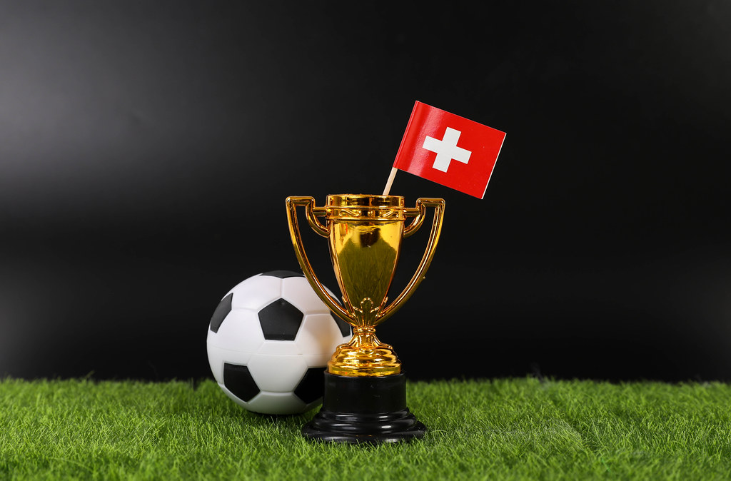 Golden trophy and football ball with flag of Switzerland