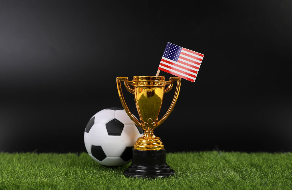 Golden trophy and football ball with flag of USA
