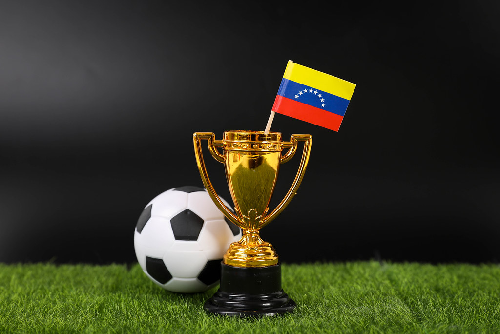 Golden trophy and football ball with flag of Venezuela