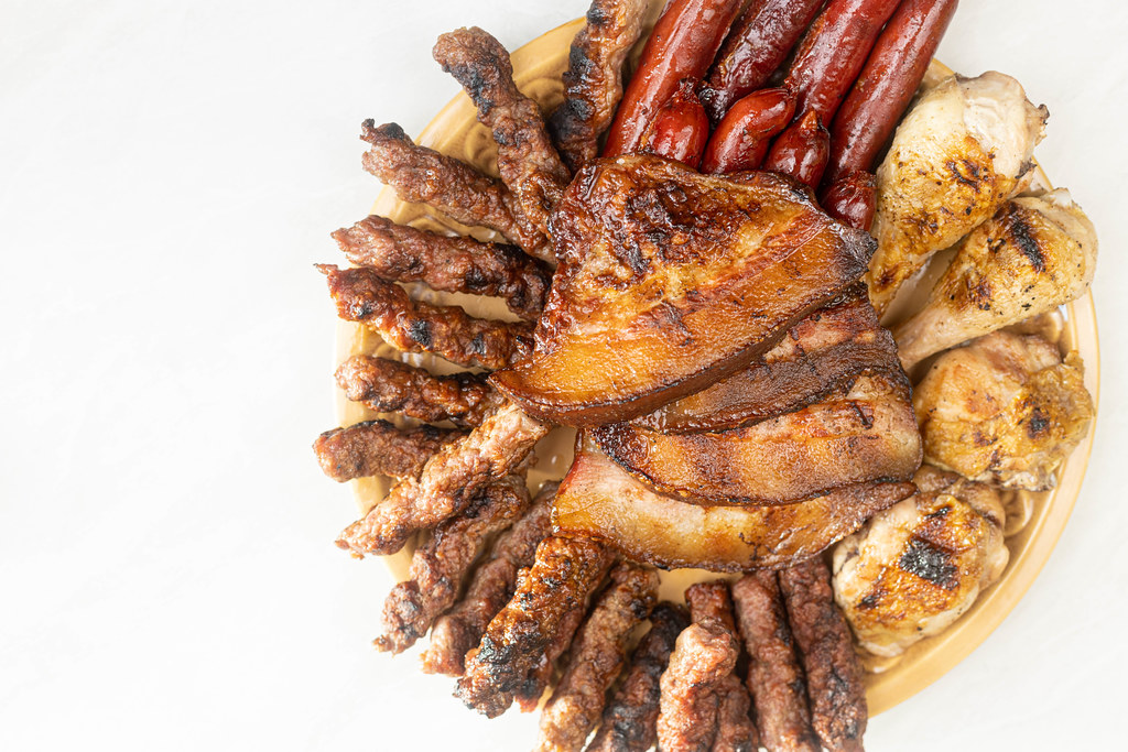 Grilled meat served on the plate with copy space above white background
