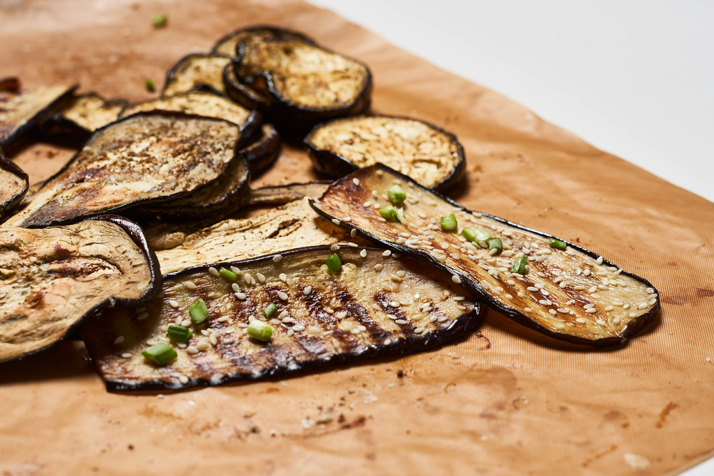 Grilled spicy eggplant slices on a cutting board