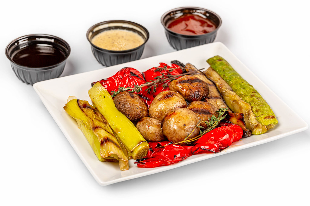 Grilled vegetables appetizer with sauces on white background