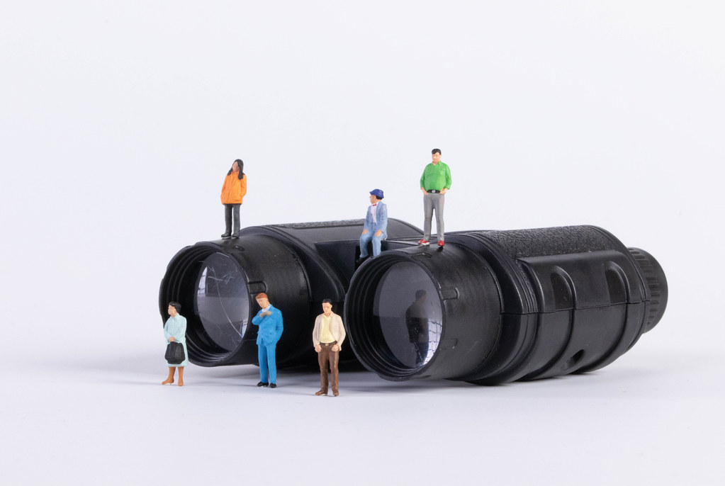 Group of people with binoculars on white background