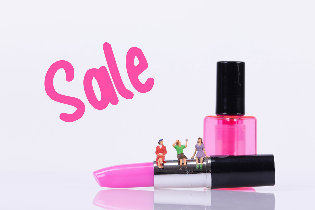 Group of womans sitting on make up with Sale text