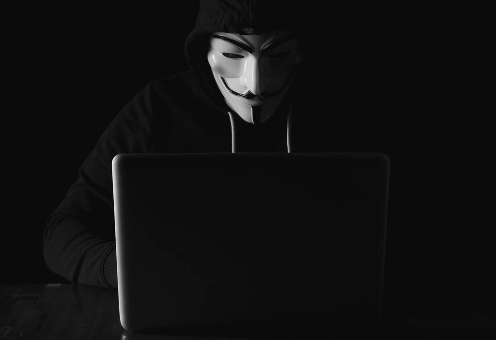 Hacker working on laptop in the dark