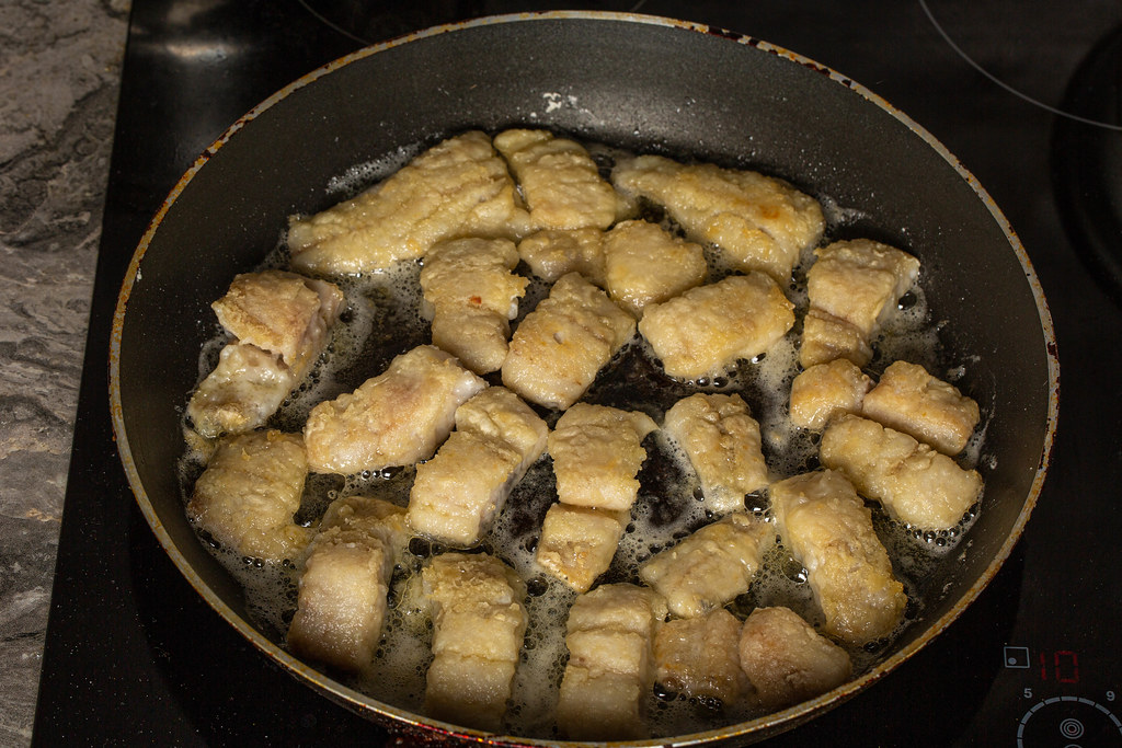 Hake fillet pieces are roasted in a skillet
