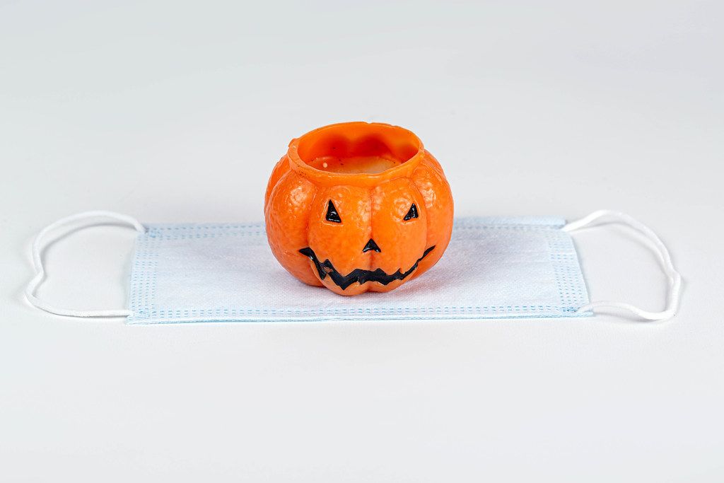 Halloween pumpkin candle and medical mask