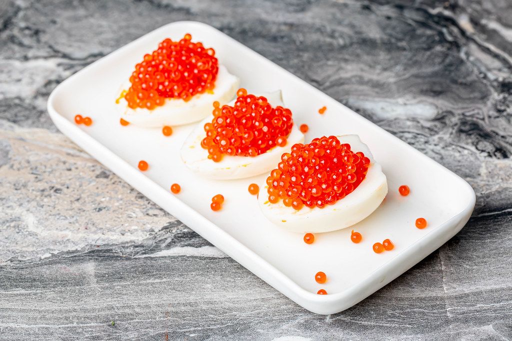 Halves of chicken eggs stuffed with red caviar