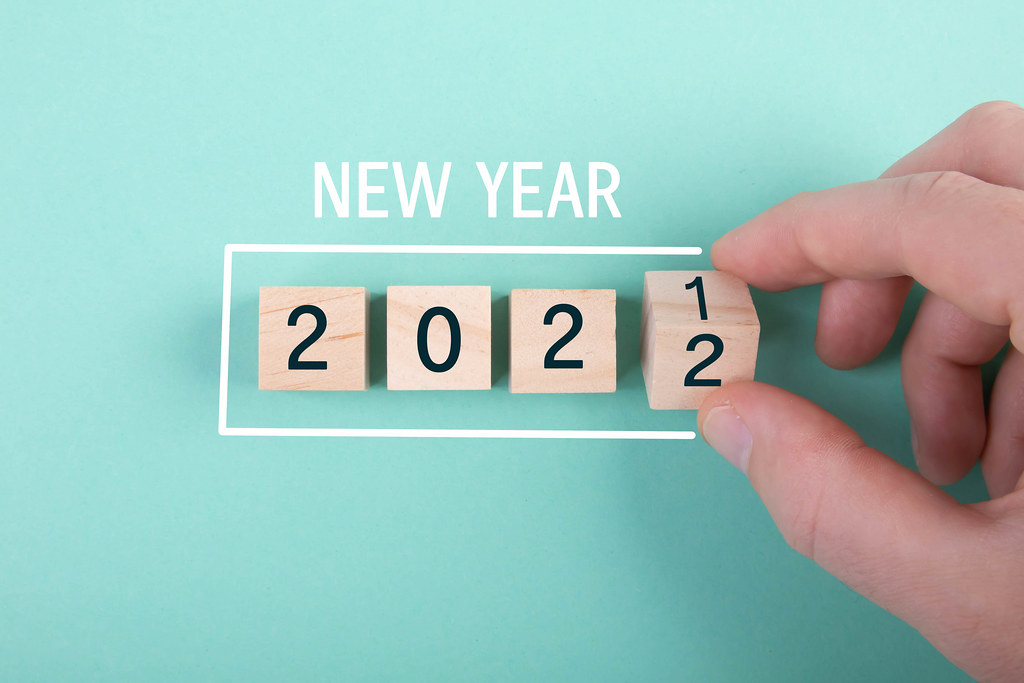 Hand and wooden blocks with New Year 2022 text