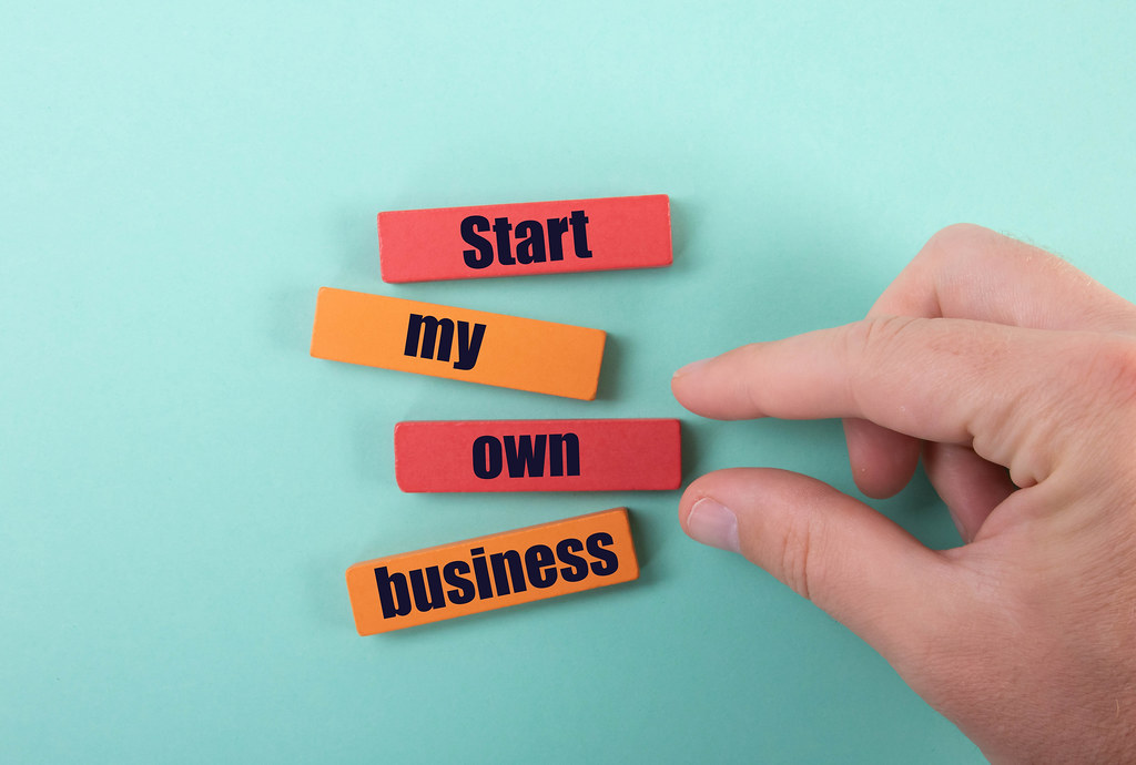 Hand and wooden blocks with Start my own business text