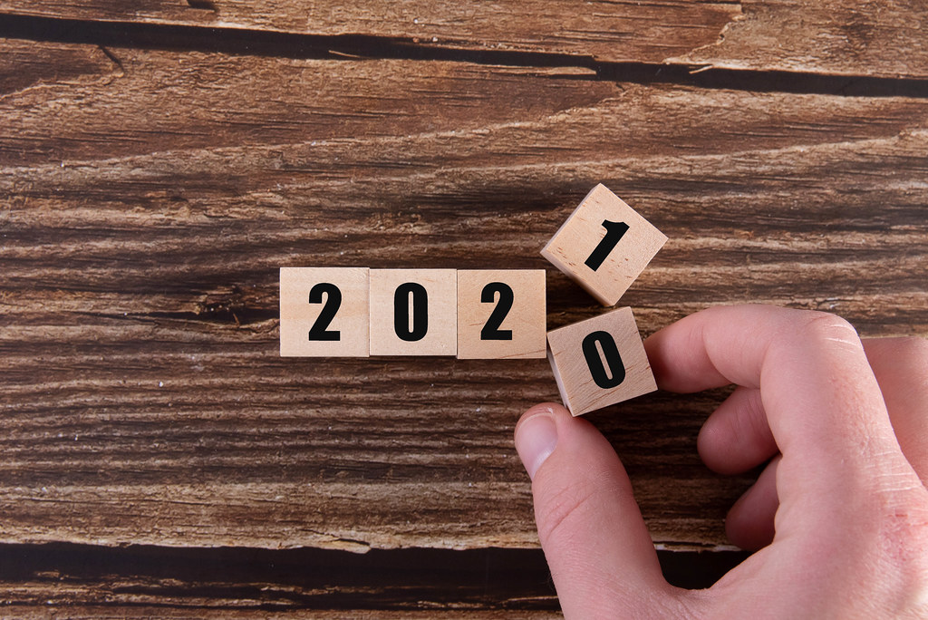 Hand flipping of wooden cubes block to change 2020 to 2021 year