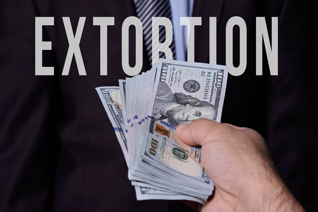 Hand giving money. Extortion concept