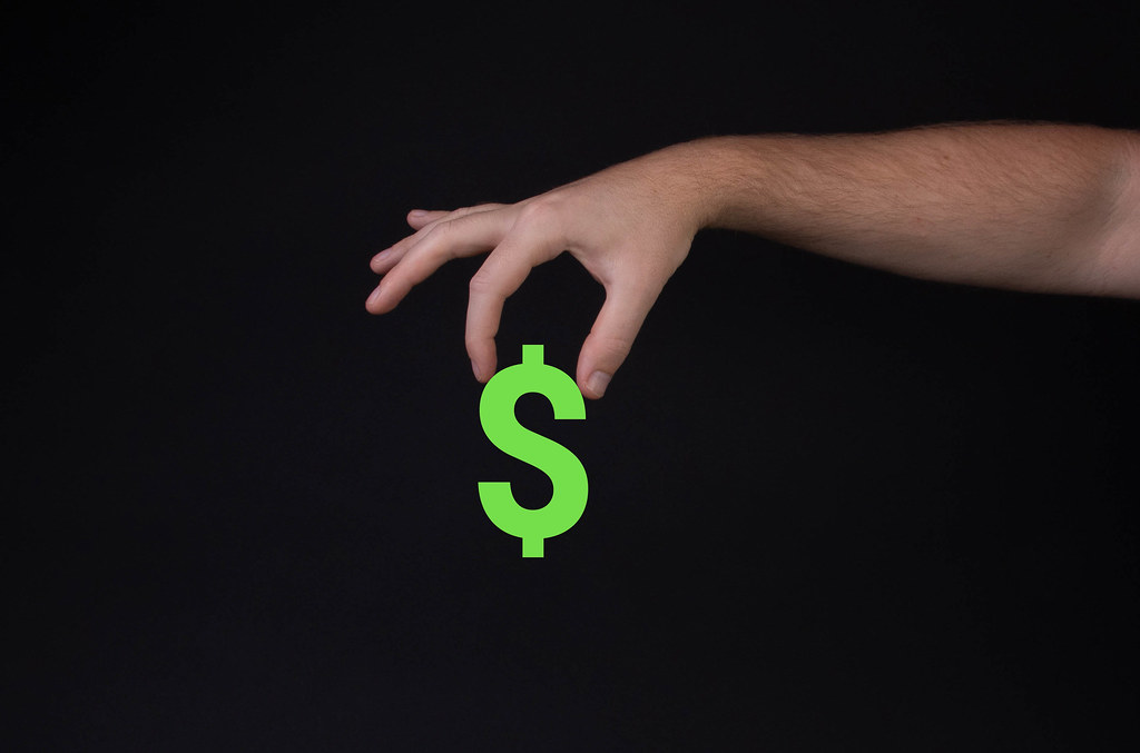 Hand holding Dollar symbol on black background