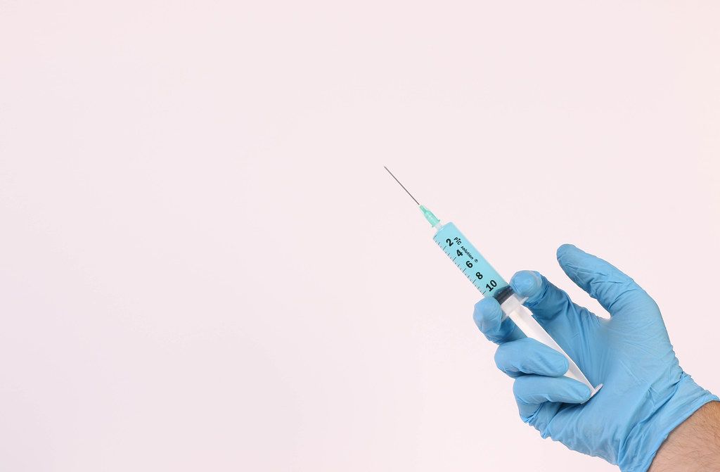 Hand holding syringe on white background