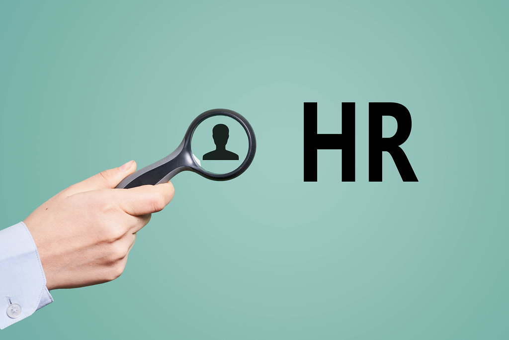 Hand holds a magnifying glass. HR, Hiring concepts