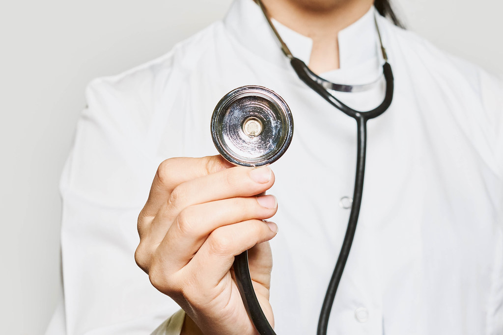 Hand of a doctor holding stethoscope disk towards the camera