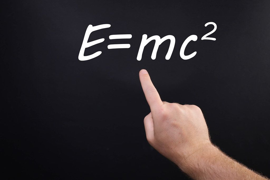 Hand pointing at Einstein Formula E=mc2