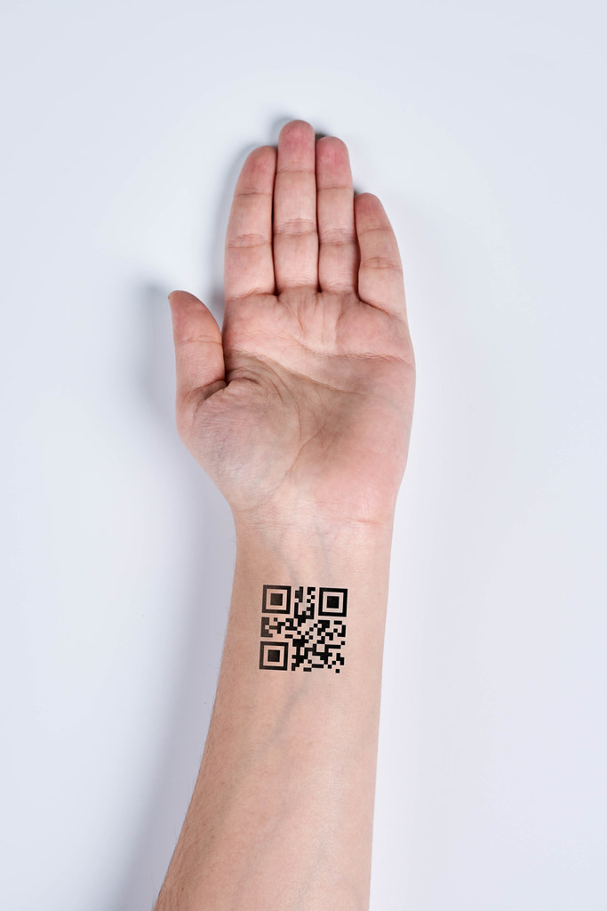 Hand with QR Code on wrist. Future of political population control. Chipization