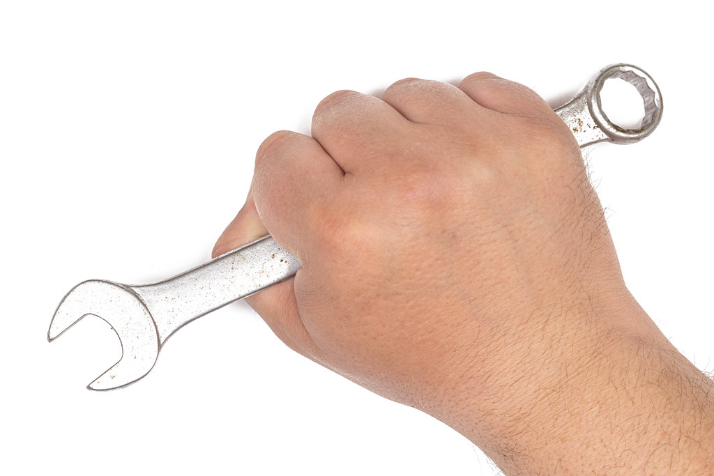 Hand with Wrench tools above white background