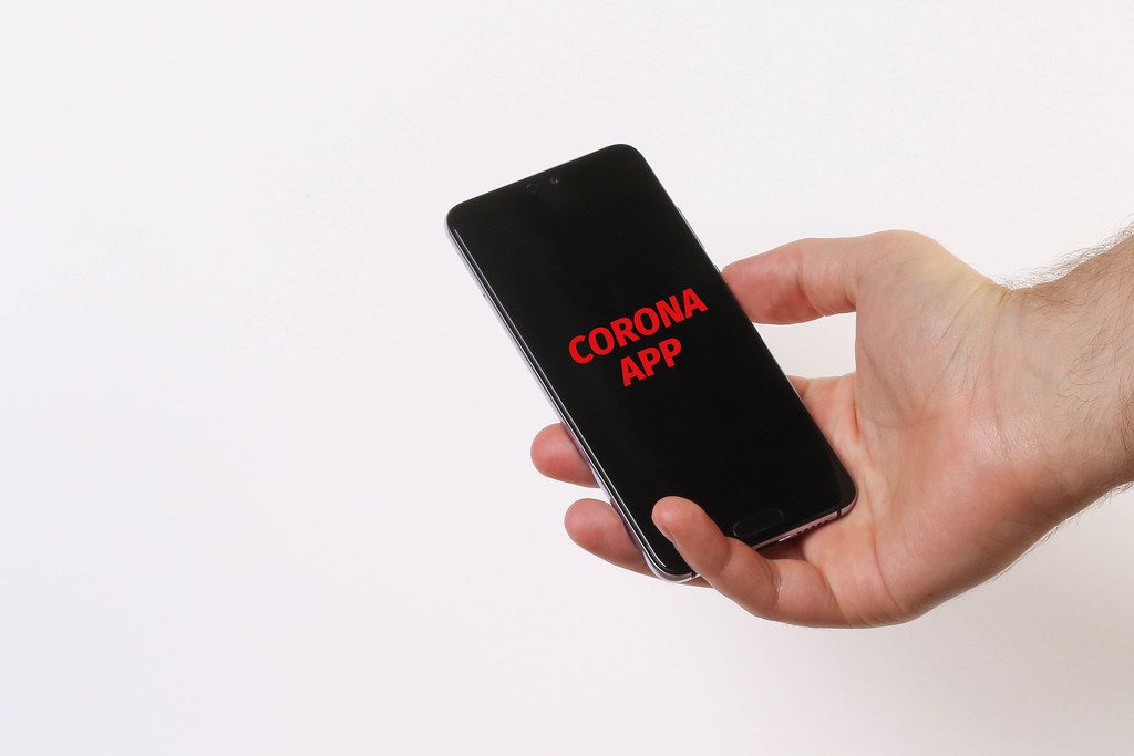 Hands holding mobile phone with Corona App text
