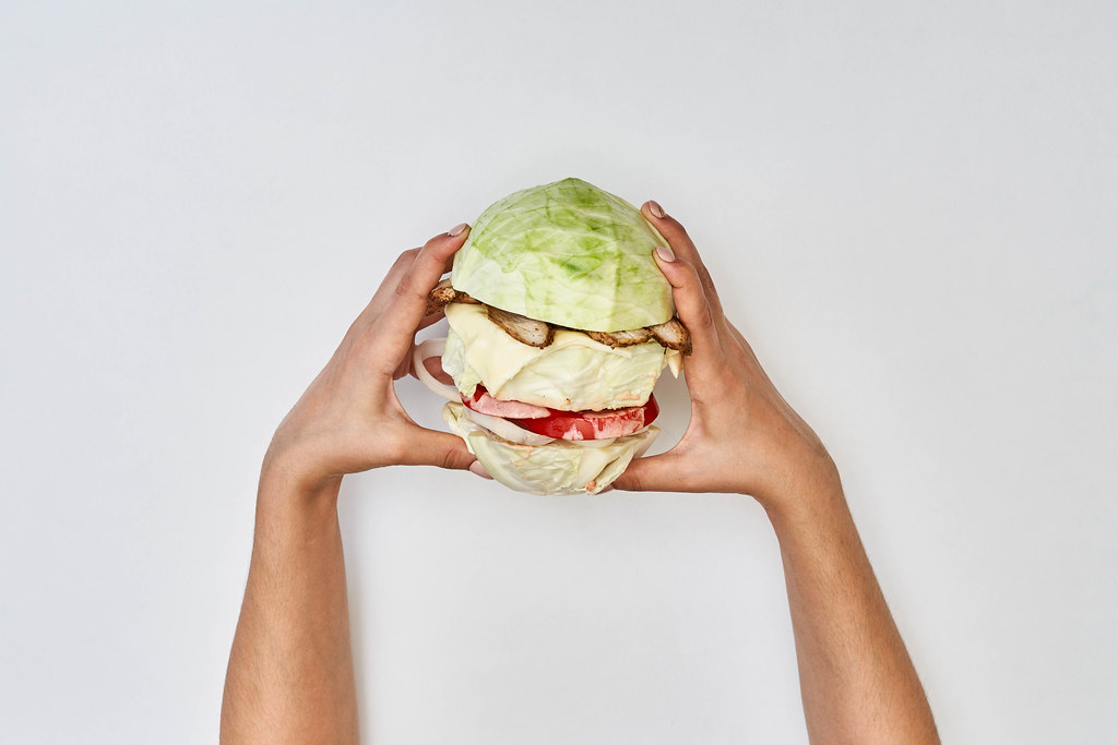 Hands of a person eating homemade vegetable hamburger