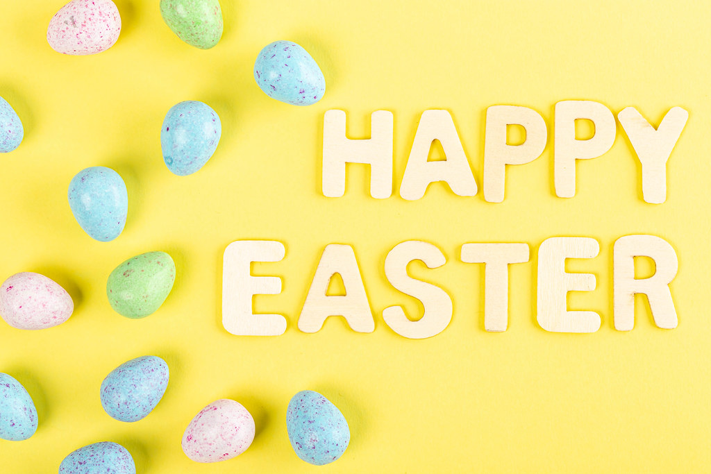 Happy easter text with chocolate eggs on yellow background