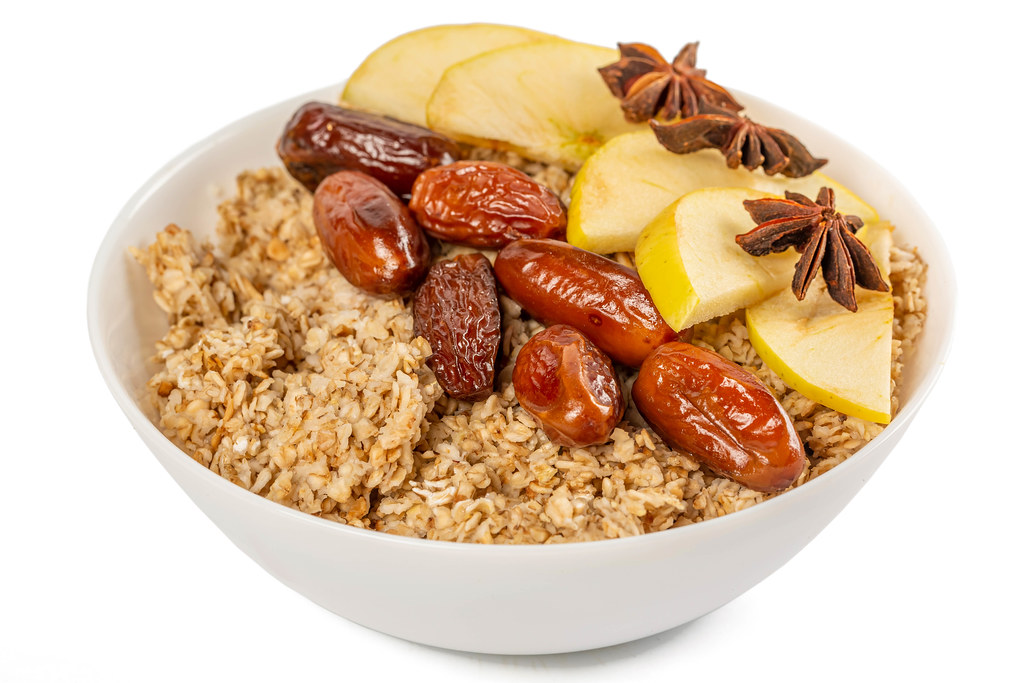 Healthy breakfast - oatmeal with apple slices, dates and star anise
