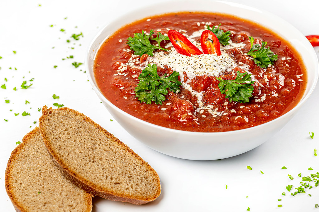 Healthy lunch - tomato puree soup with rye bread and herbs