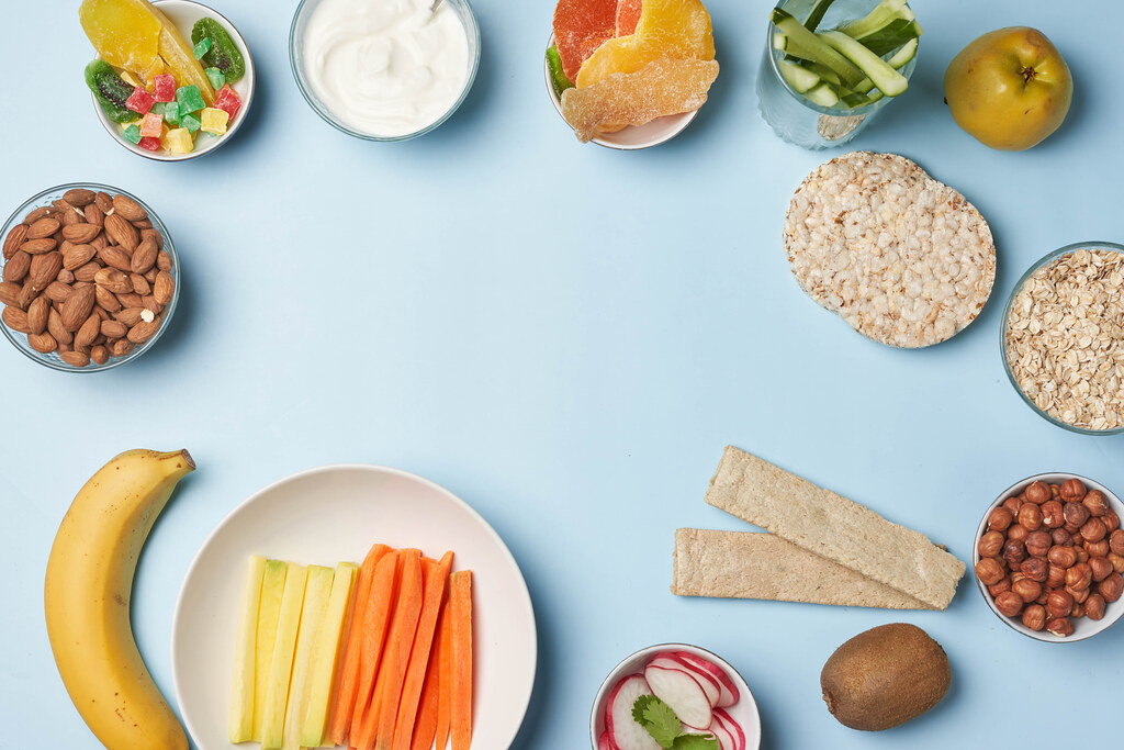 Healthy snacks on bright-colored table with copy space.