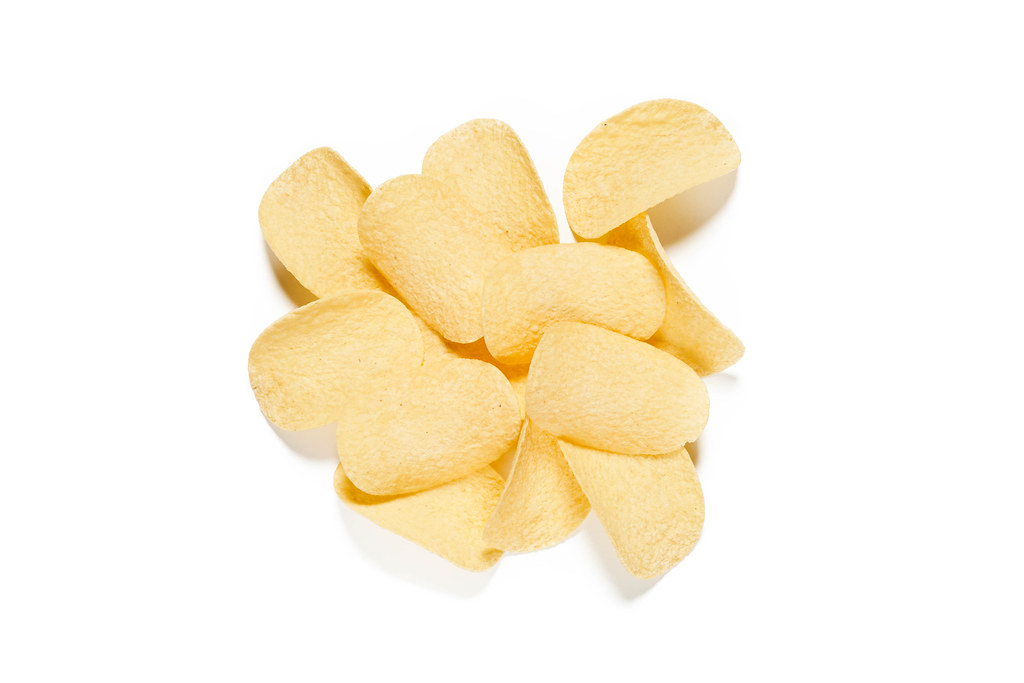 Heap of fresh potato chips isolated on white