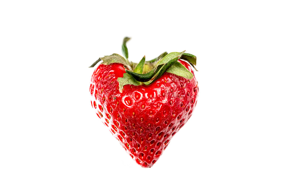 Heart shaped strawberry on white