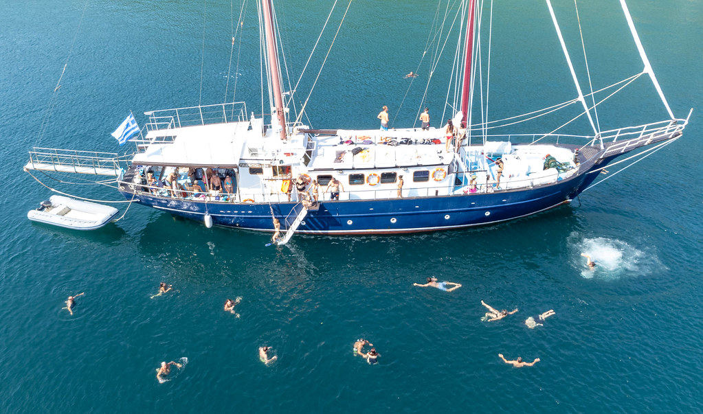 Holiday fun in Greece in summer 2021: tourists swimming in the waters of Peristera during a sailing boat trip