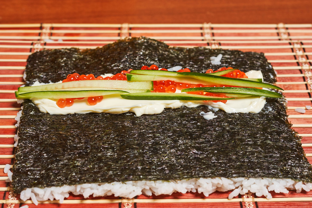 Homemade sushi - nori seaweed filled with rice, cucumber slices and red caviar